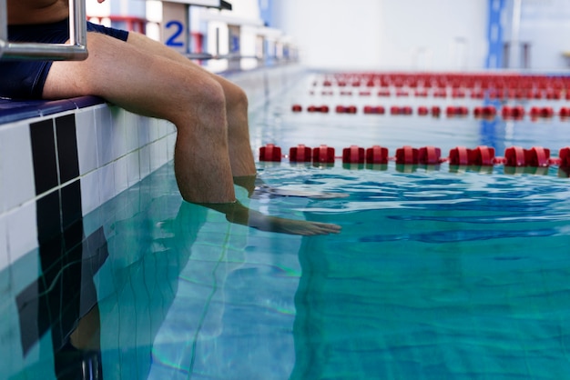Man legs entering water of swimming pool