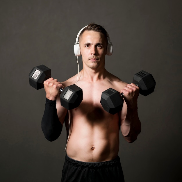 Man lifthing weights while listening music