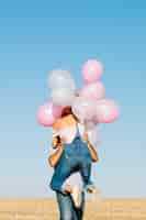 Free photo man lifting woman with balloons