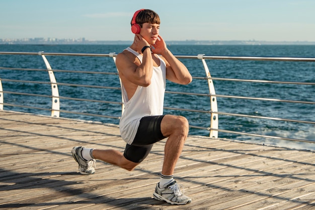 Man listening to music at the beach while training