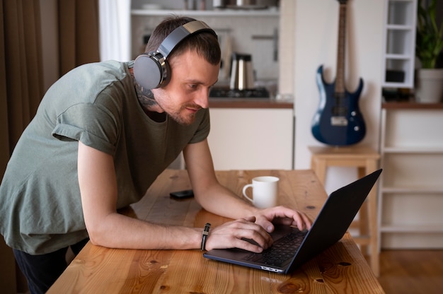 暇なときにヘッドフォンで音楽を聴いている男性