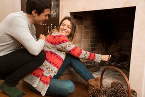 man looking at young woman ignite big match in the fireplace