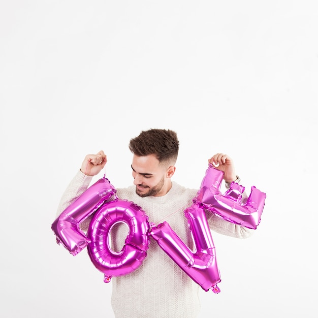 Man looking at balloon love writing