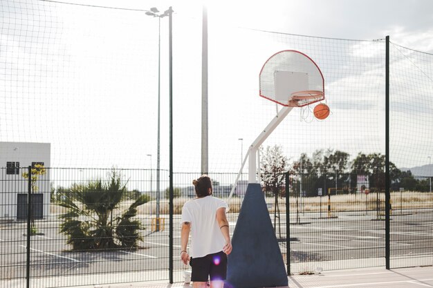 Man looking at basketball going through hoop