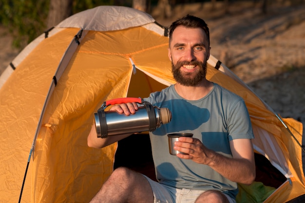 カメラを見てお茶を注ぐ男