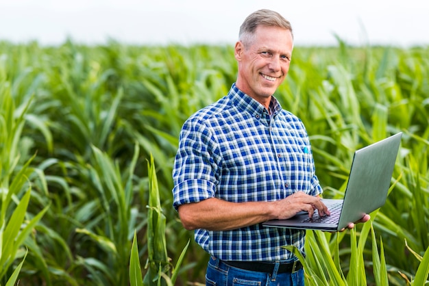 Man looking at camera with a laptop