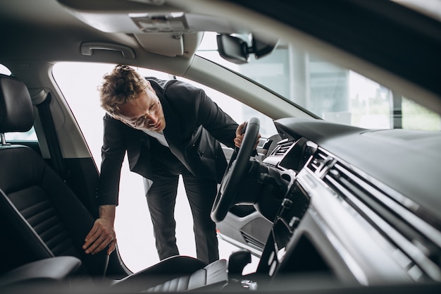 Man looking at a car in a car showroom