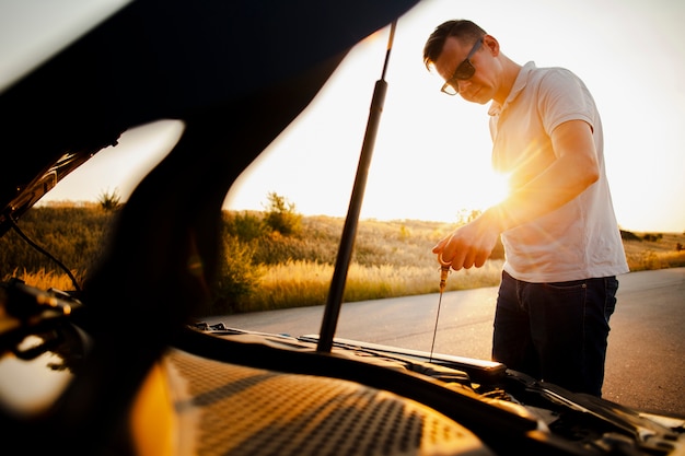 Foto gratuita uomo che guarda le condizioni dell'auto