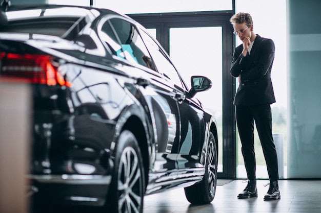 Man looking at a car and thinking of a purchase