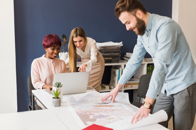 Man looking at draft near female colleagues