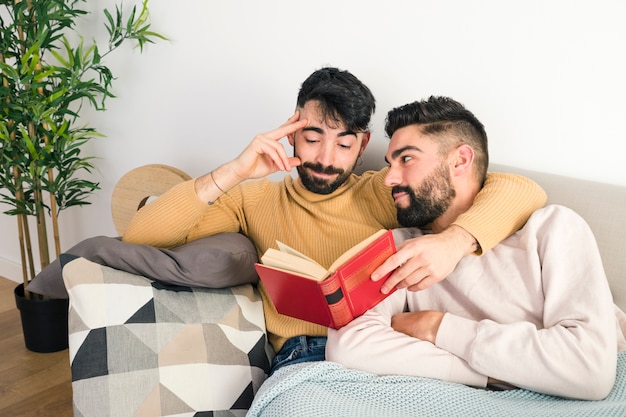 家で本を読んで彼のボーイフレンドを見ている男