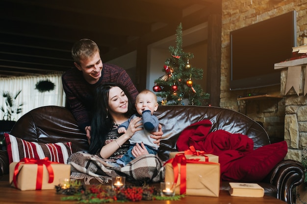 Free photo man looking at his wife while she holds her baby in her arms