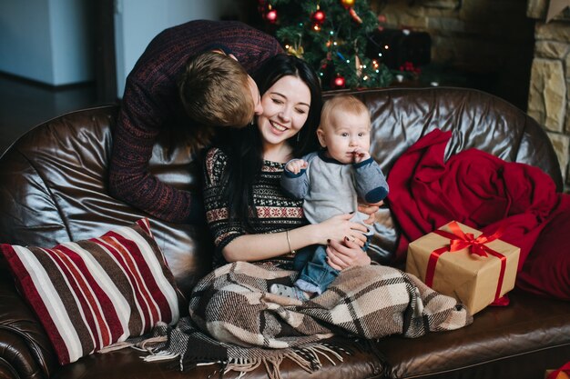 Man looking at his wife while she holds her baby in her arms