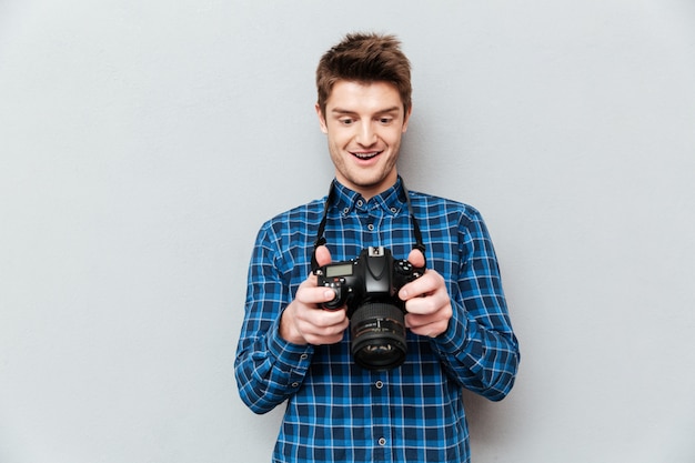 Man looking at images on camera and surprising