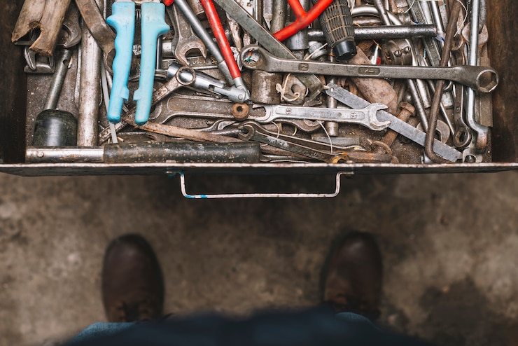 Free Photo man looking into drawer full of tools