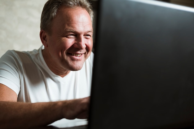 Free photo man looking at laptop close up