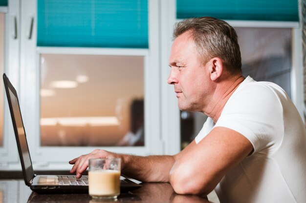 Man looking at laptop side view