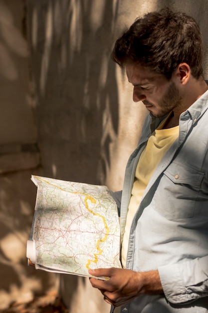 Free photo man looking at map in shadow