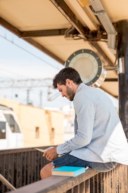 Man looking on a map and waiting for train