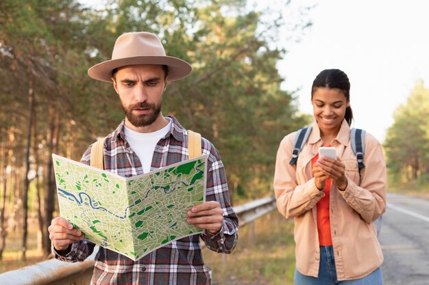 Man looking at a map while traveling with his girlfriend