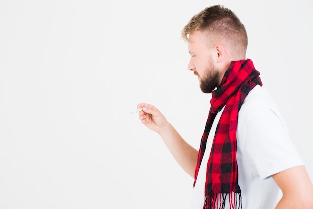 Man looking at mercury thermometer