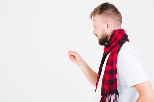 Man looking at mercury thermometer