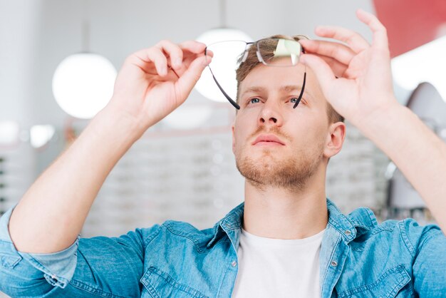 Man looking for new glasses at optometrist