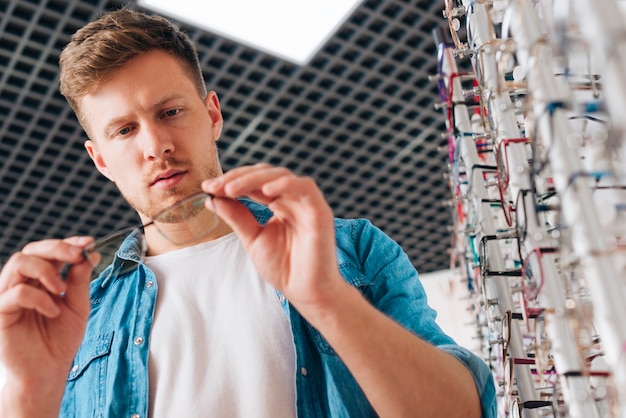 Man looking for new glasses at optometrist