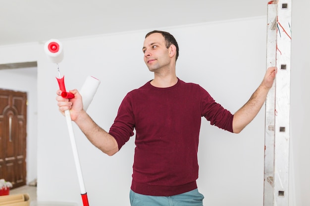 Man looking at paint roller