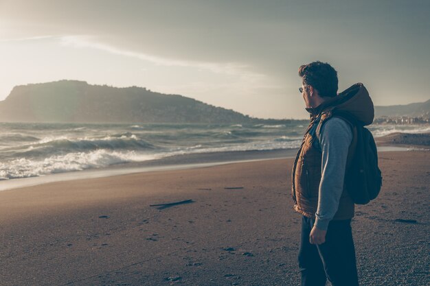 man looking at sein beach during daytime and looking thoughtful