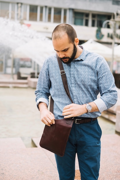 Man looking for something in bag