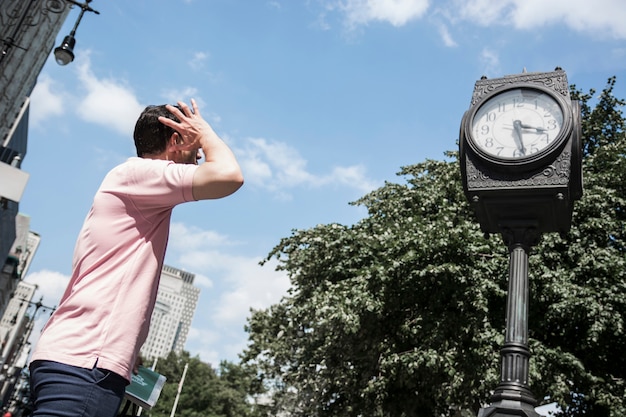 Man looking at street clock