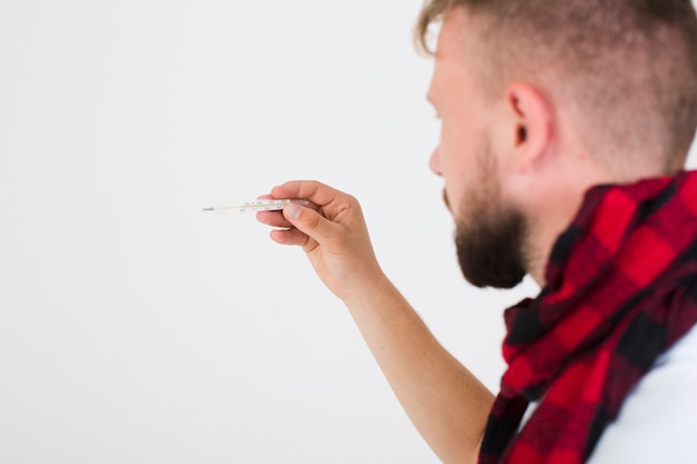 Man looking at thermometer