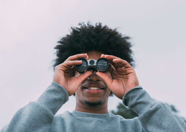 Foto gratuita uomo che guarda attraverso il binocolo