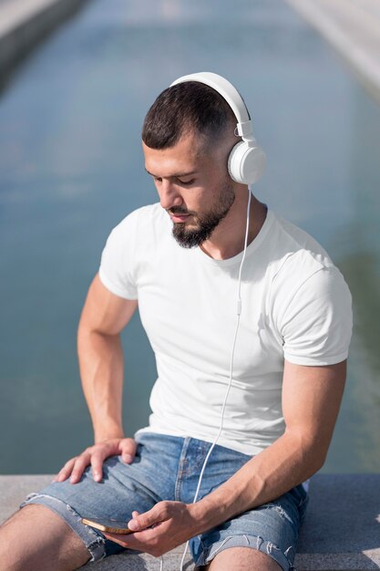 Man looking through his phone while listening music