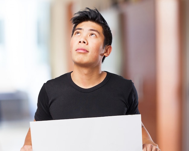 Man looking up while holding a white sign