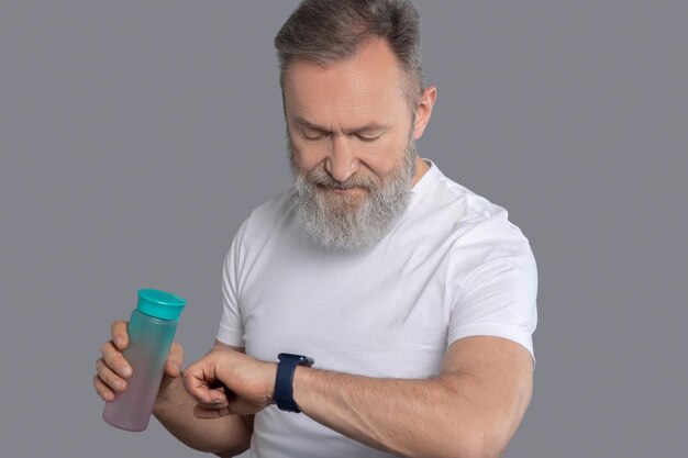 A man looking at the watch on his hands