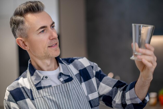 Man looking with interest at glass in his hand