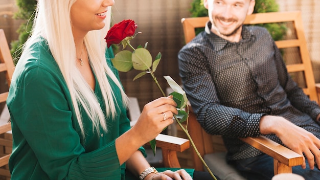 Man looking at woman holding beautiful red rose