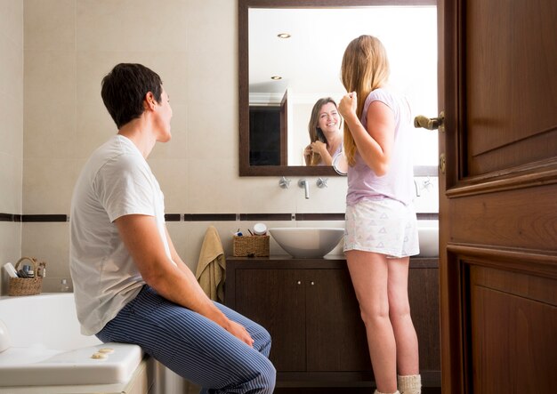 Man looking at woman looking in the mirror