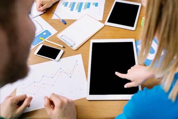 Man looking at woman touching digital tablet screen on table