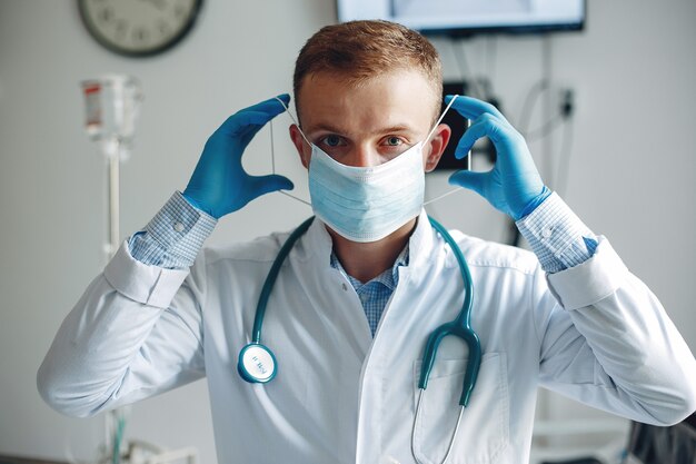 Man looks at the camera. Student practice medicine. Nurse in a bathrobe and stethoscope.