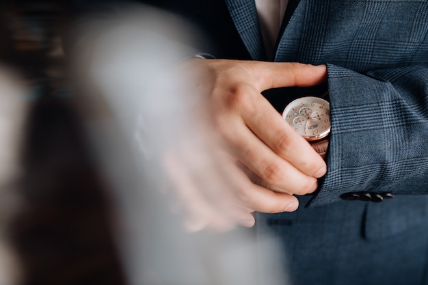 Man looks at the watch on his hand