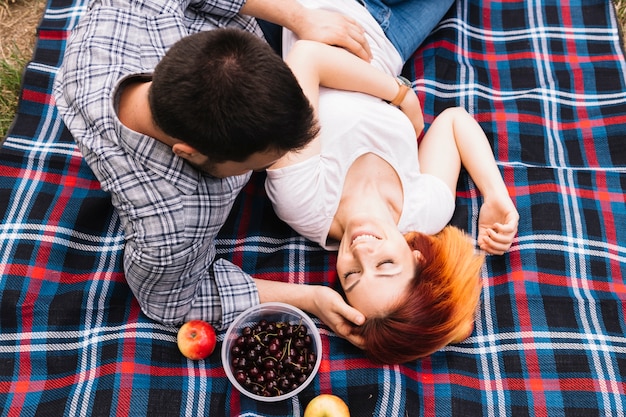 Man loving her girlfriend lying on blanket