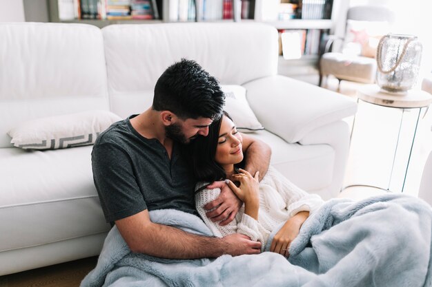 Foto gratuita uomo che ama la sua ragazza seduta nella coperta di pelliccia