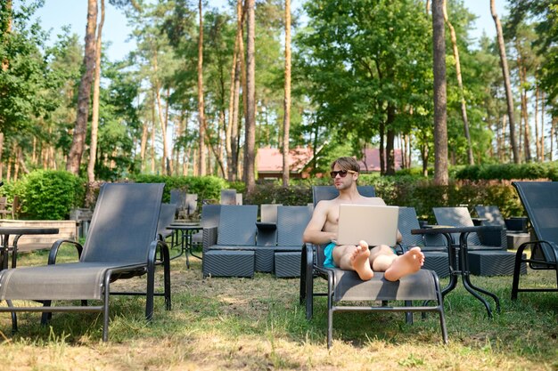 Man lying on a chaise longue and sunbathing