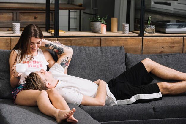 Man lying on woman lap on couch 