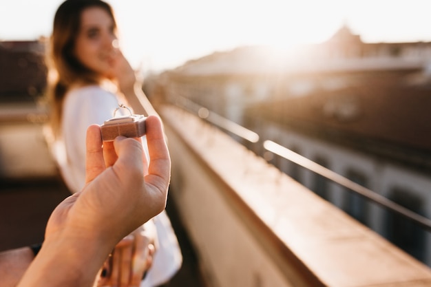 Foto gratuita l'uomo fa un'offerta di matrimonio alla ragazza in piedi sul tetto in una giornata di sole