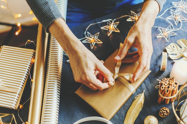 Free photo man making bow from ribbon on gift