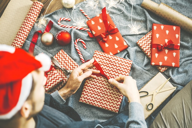 Man making bow from ribbon on gift